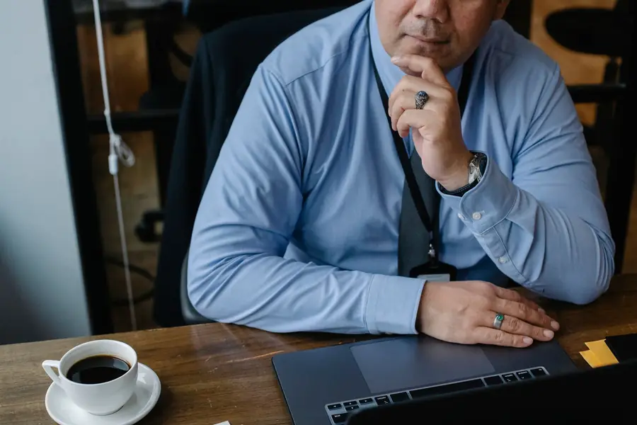Business owner at desk thinking through operational bottlenecks and manual processes