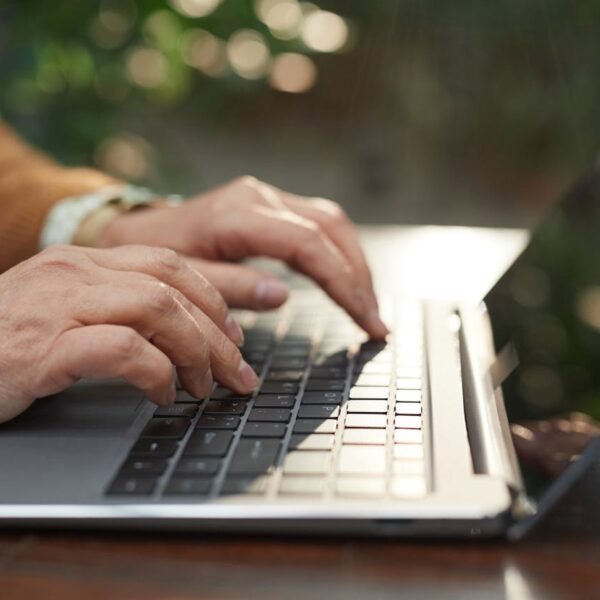 Close-up of a person typing on a laptop with a chat-style interface visible, illustrating an AI-powered chatbot conversation on a small business website.