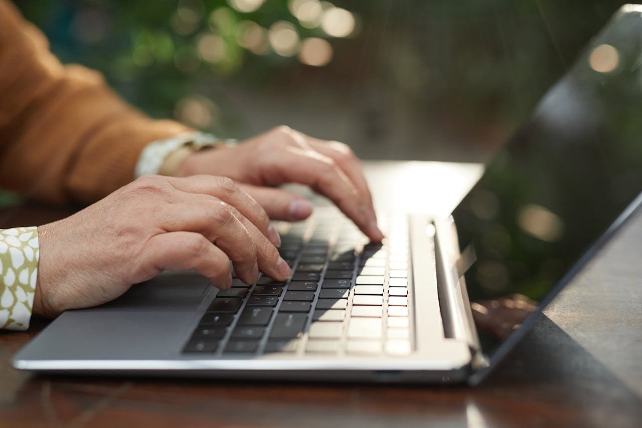 Close-up of a person typing on a laptop with a chat-style interface visible, illustrating an AI-powered chatbot conversation on a small business website.