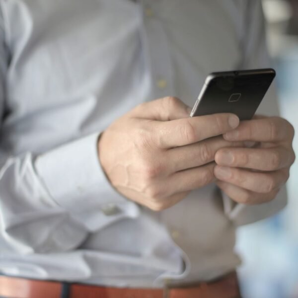 Small business owner reviewing email and text notifications on a smartphone