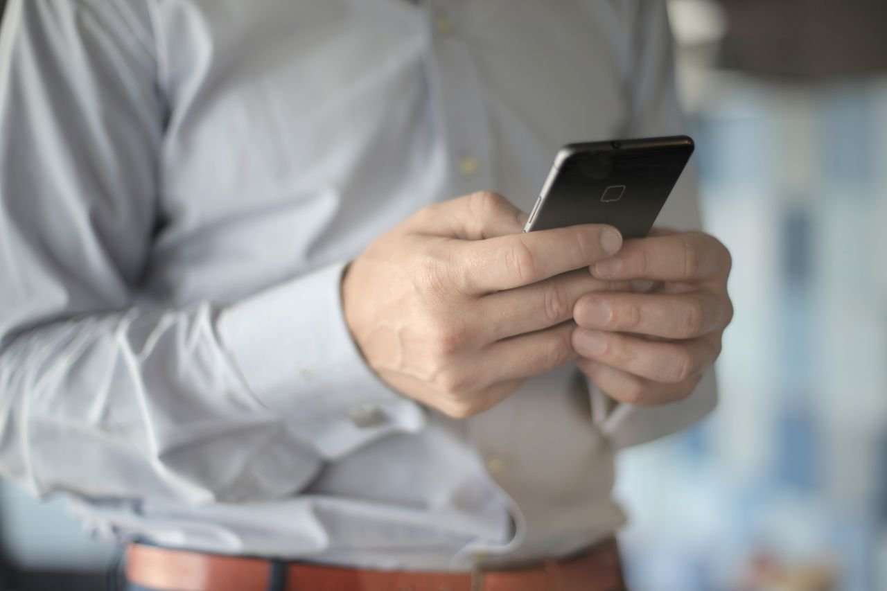 Small business owner reviewing email and text notifications on a smartphone