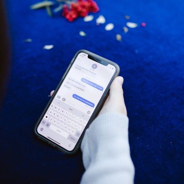 Hand holding a smartphone showing a text message conversation