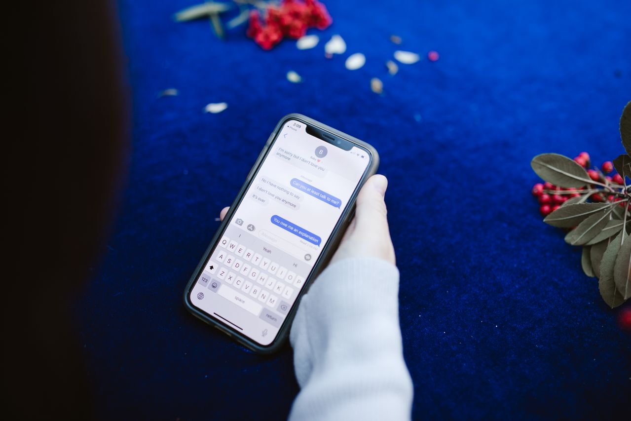 Hand holding a smartphone showing a text message conversation