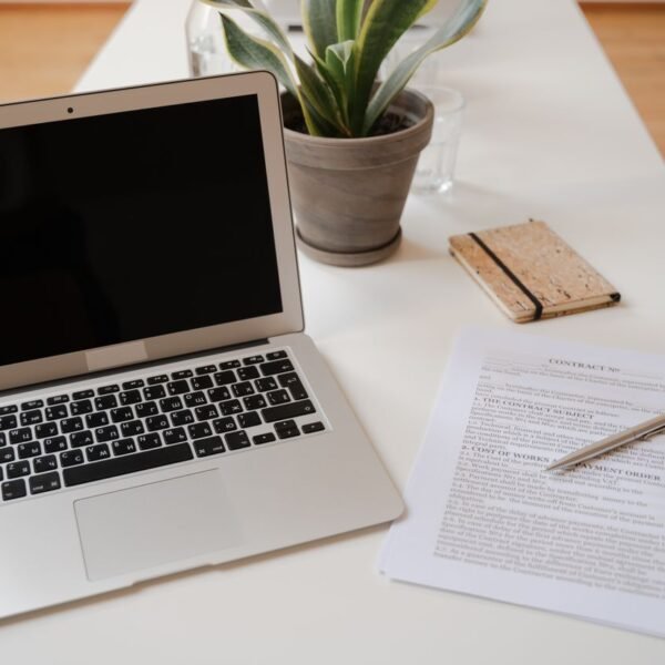 Service business owner reviewing quotes and invoices on a laptop and smartphone