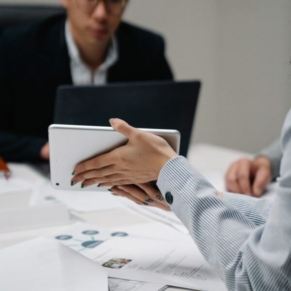 Person signing a digital document on a tablet at a desk