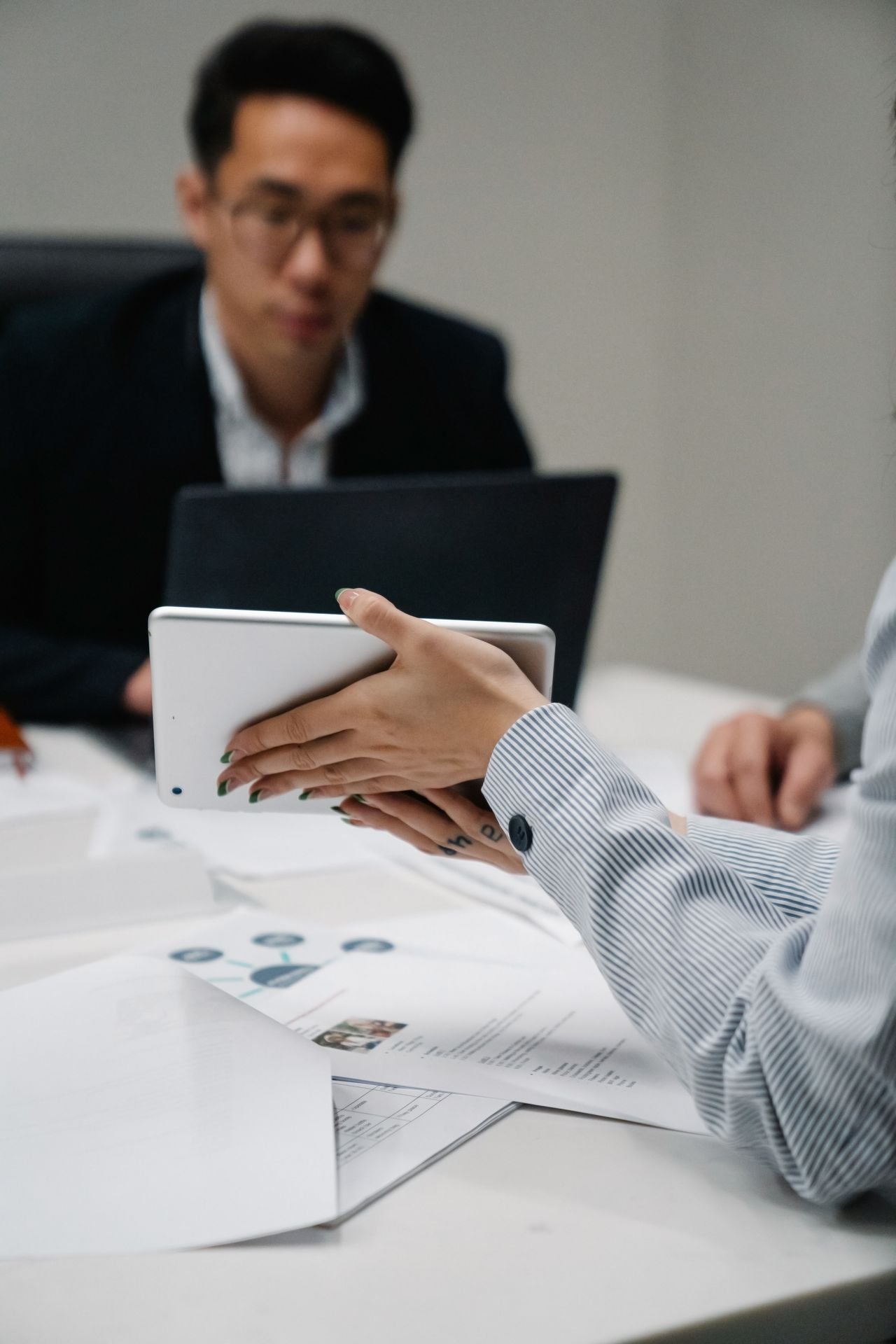 Person signing a digital document on a tablet at a desk