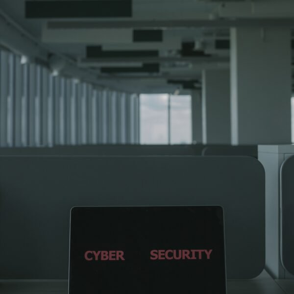 A laptop displaying the words Cyber Security on its screen in a modern office setting