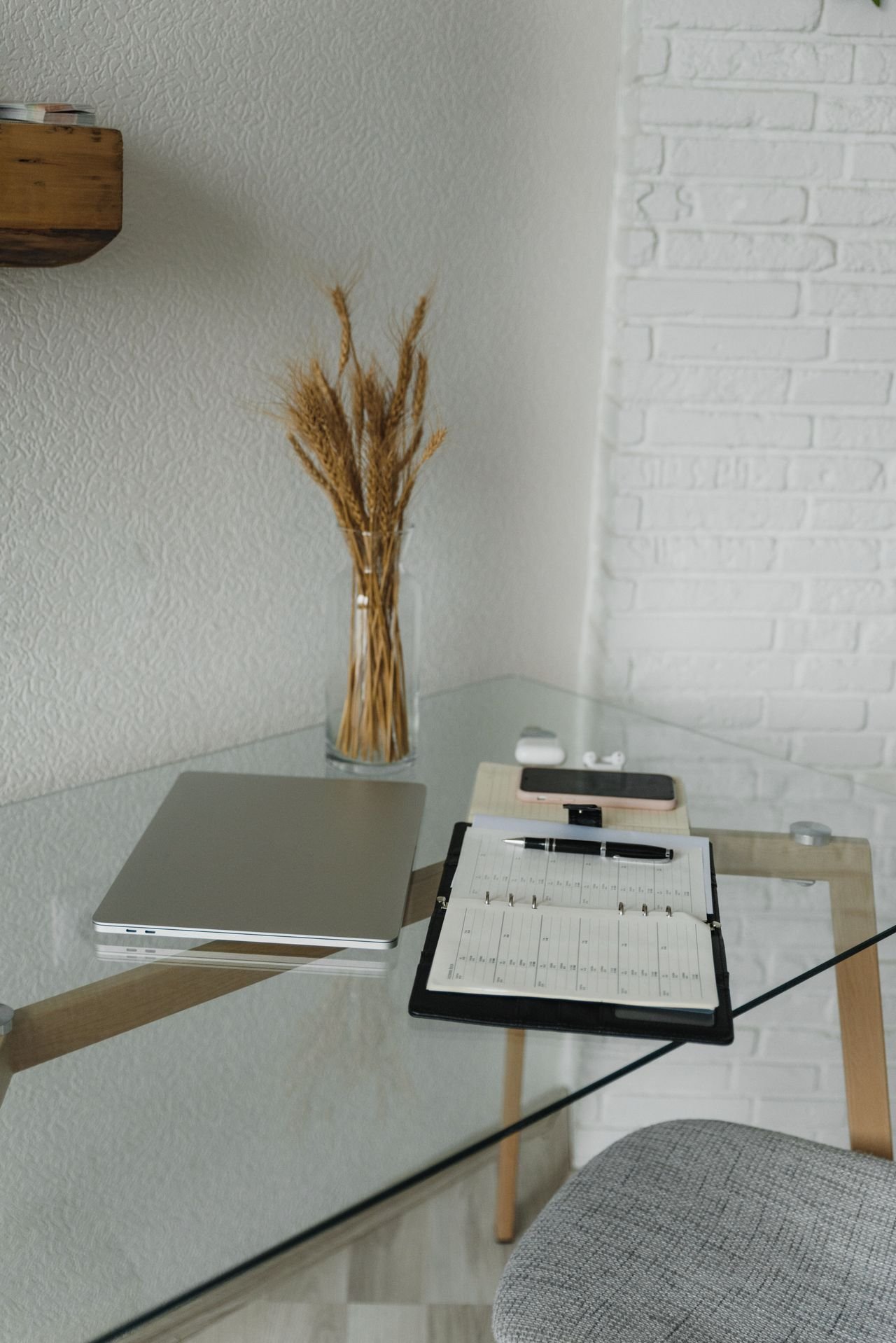 A laptop, planner, and pen on a clean desk, ready for workflow planning